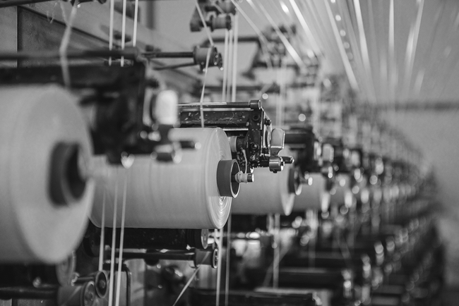 spools on=f fabrics on a row of machines