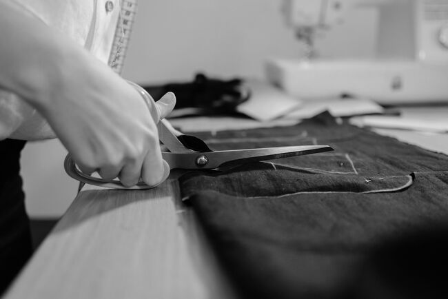 a man with scissors cutting fabric
