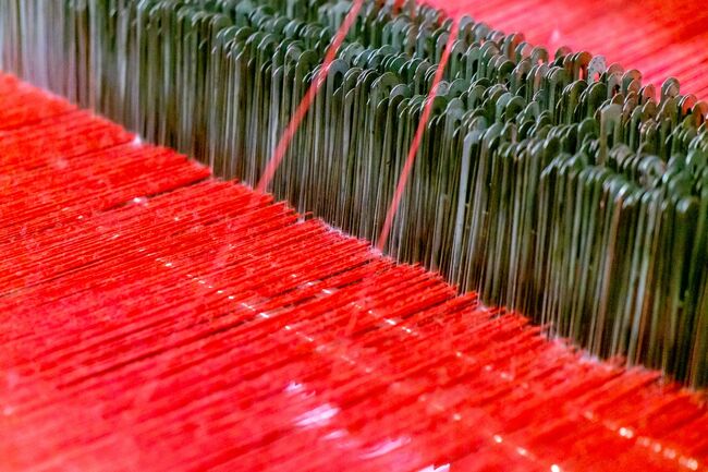 a close up of red thread on a machine